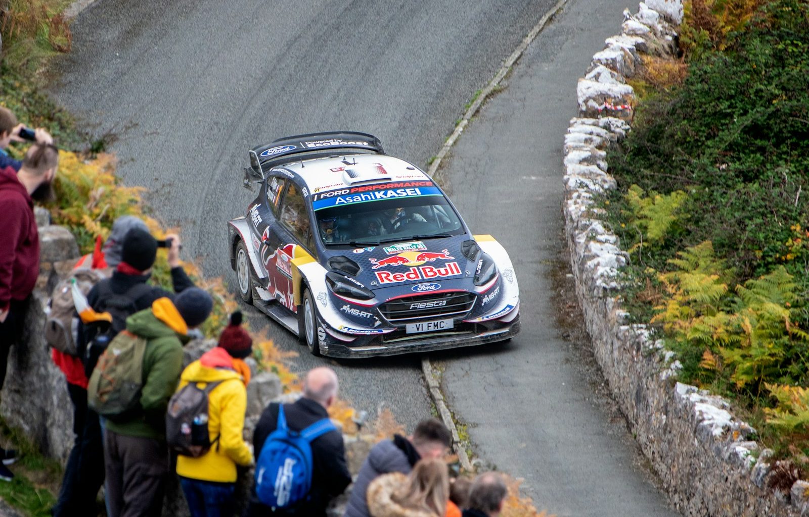 people watching passing race car