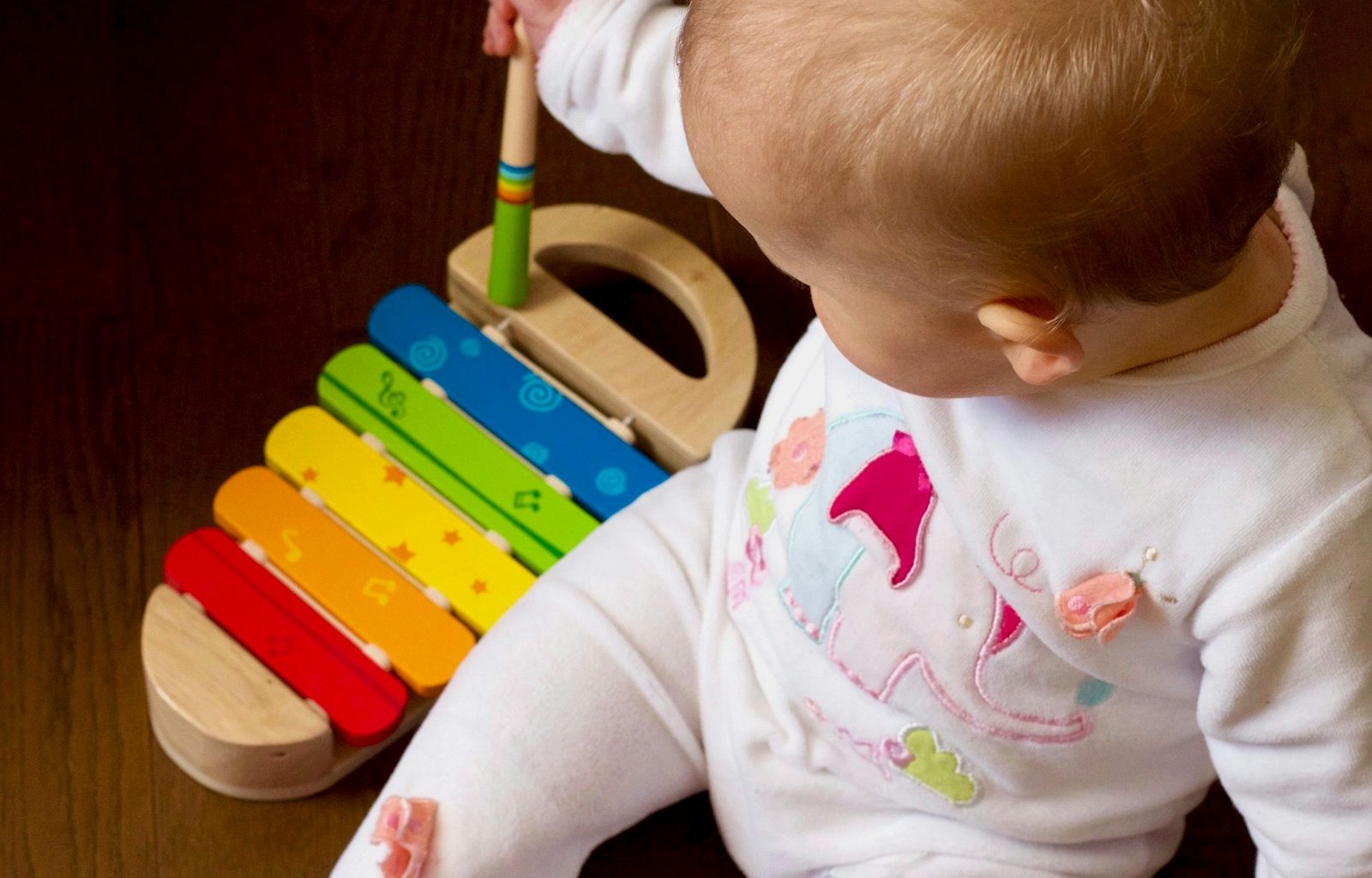 baby playing multicolored xylophone toy