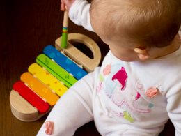 baby playing multicolored xylophone toy