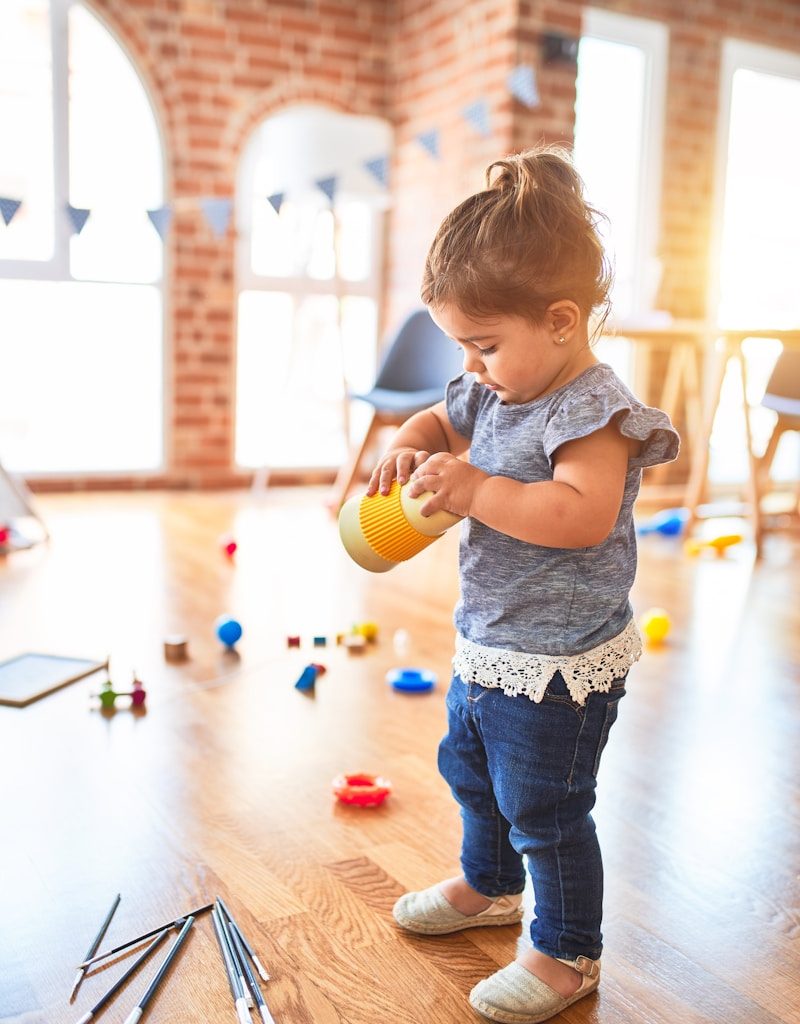 girl in blue denim dungaree pants holding blue and white polka dot handbag