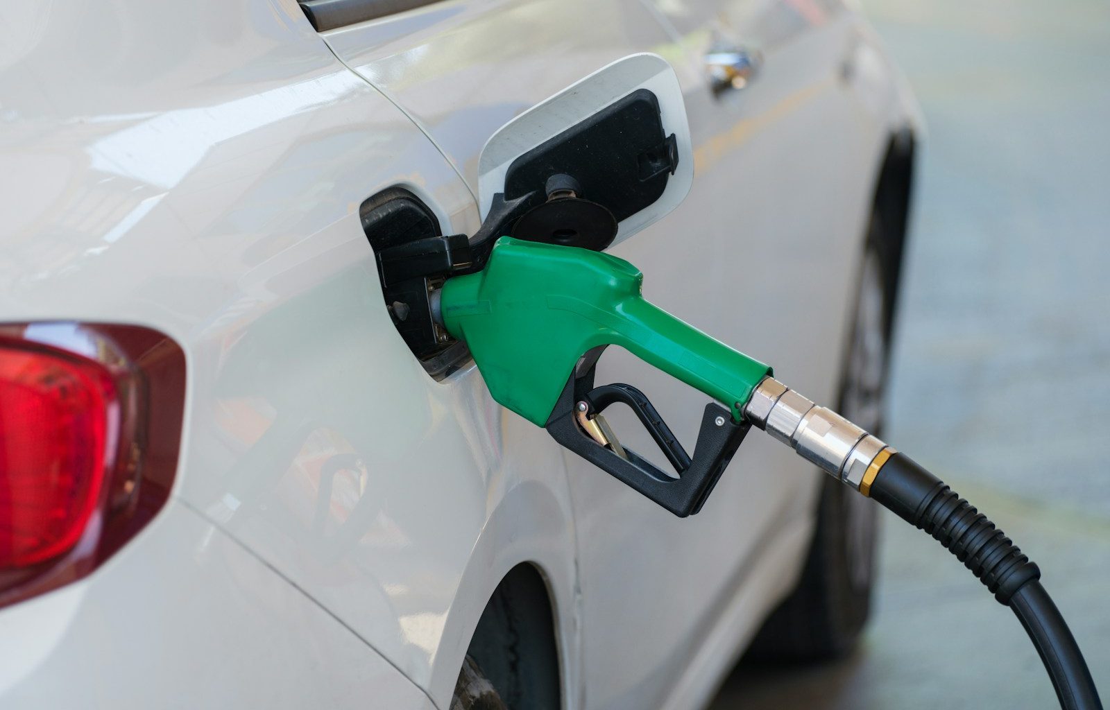 a white car with a green gas pump