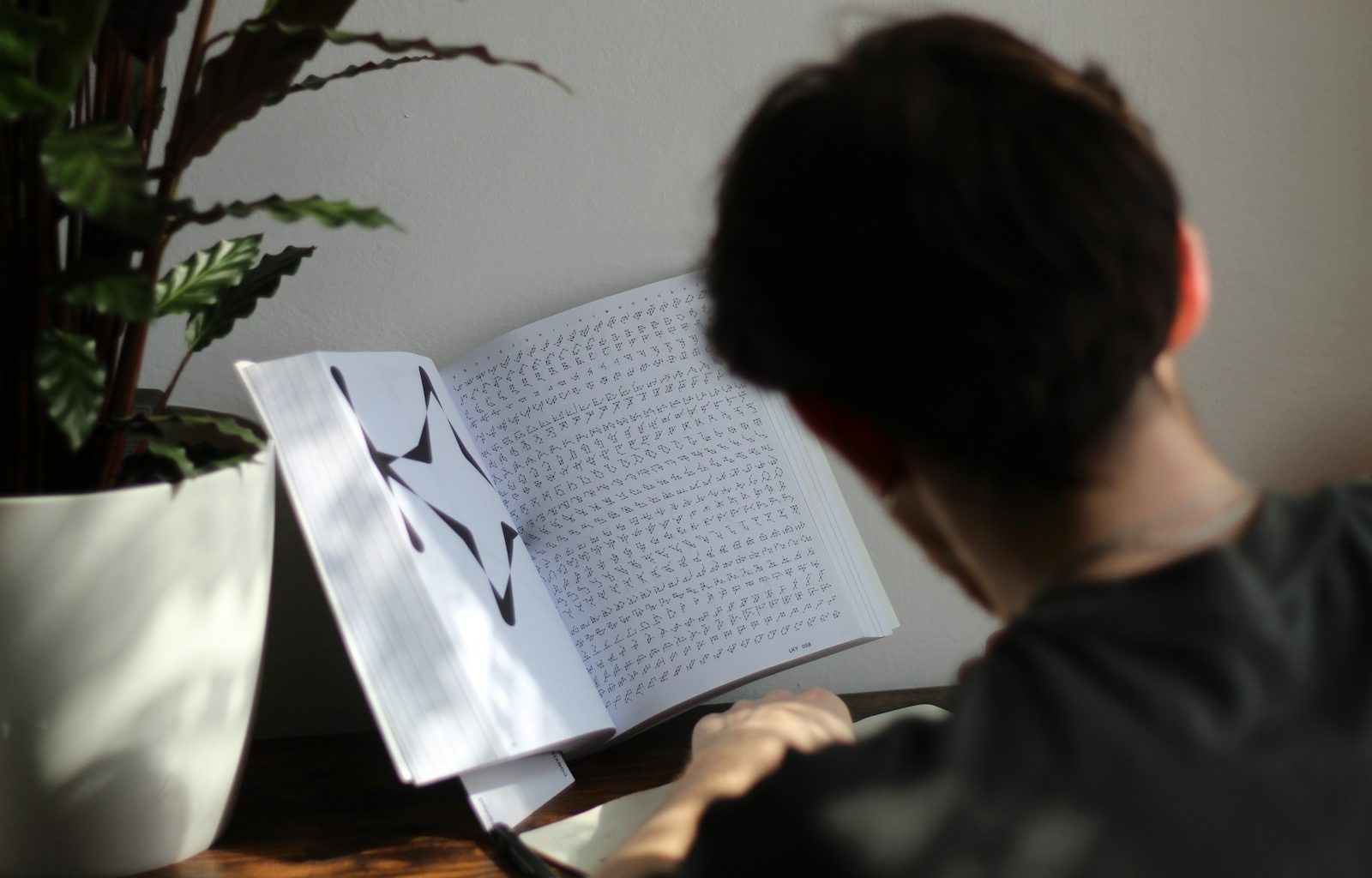 a person sitting at a table reading a book