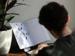 a person sitting at a table reading a book