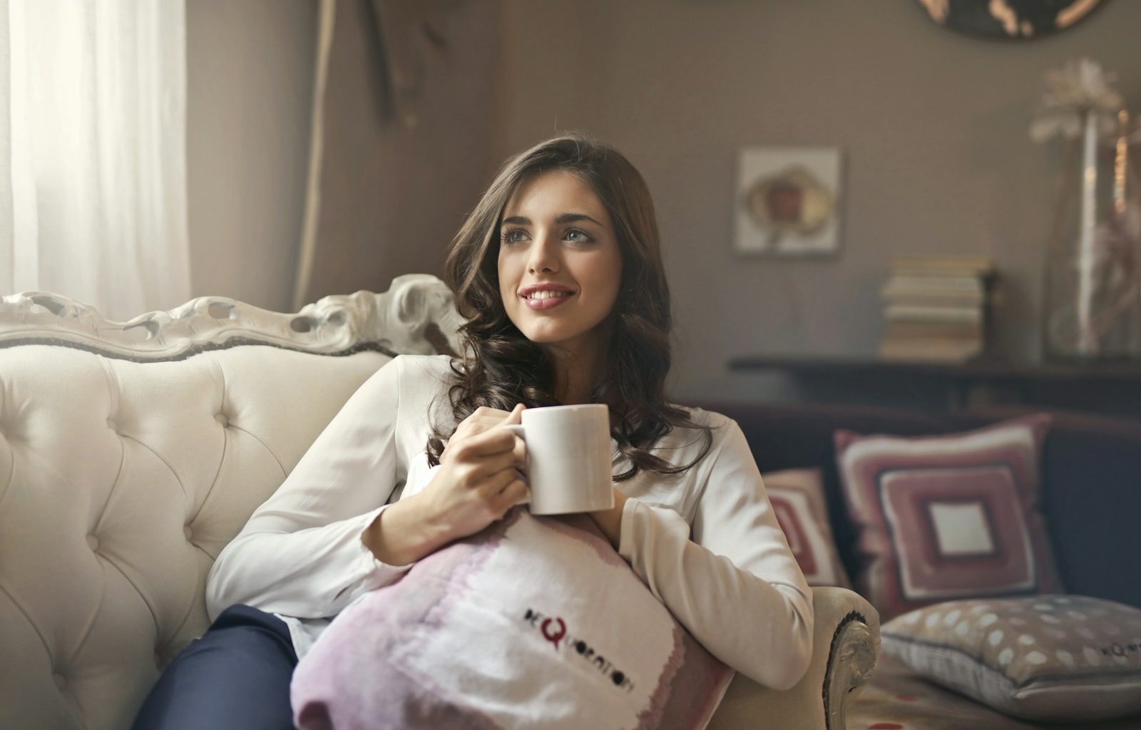 woman holding mug sitting on sofa