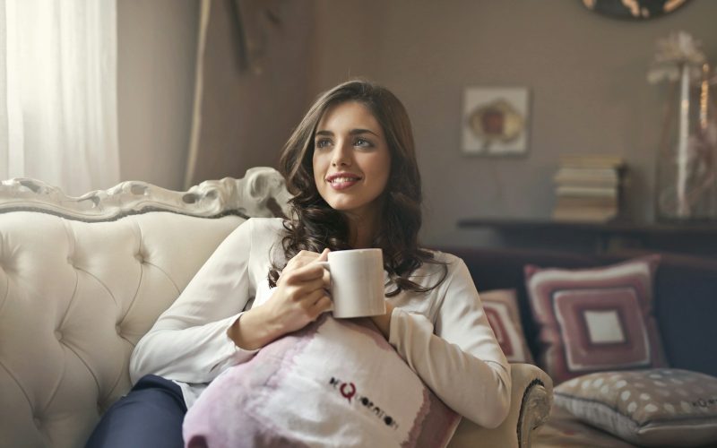 woman holding mug sitting on sofa