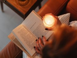 a woman sitting on a couch reading a book