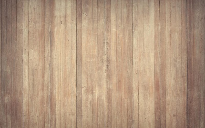 Houten vloerplanken met zichtbare vochtschade en verkleuringen langs de naden