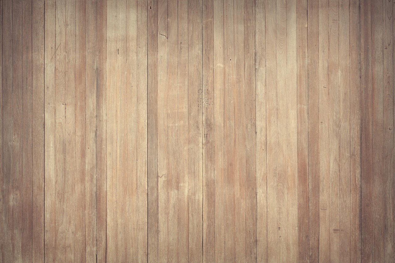 Houten vloerplanken met zichtbare vochtschade en verkleuringen langs de naden