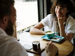 Twee vrienden in gesprek aan een tafel met koffie
