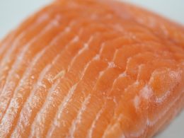 Verse zalmfilet met zichtbare oranje kleur op een houten plank